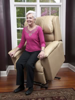 Woman in pink shirt standing up from lift chair.